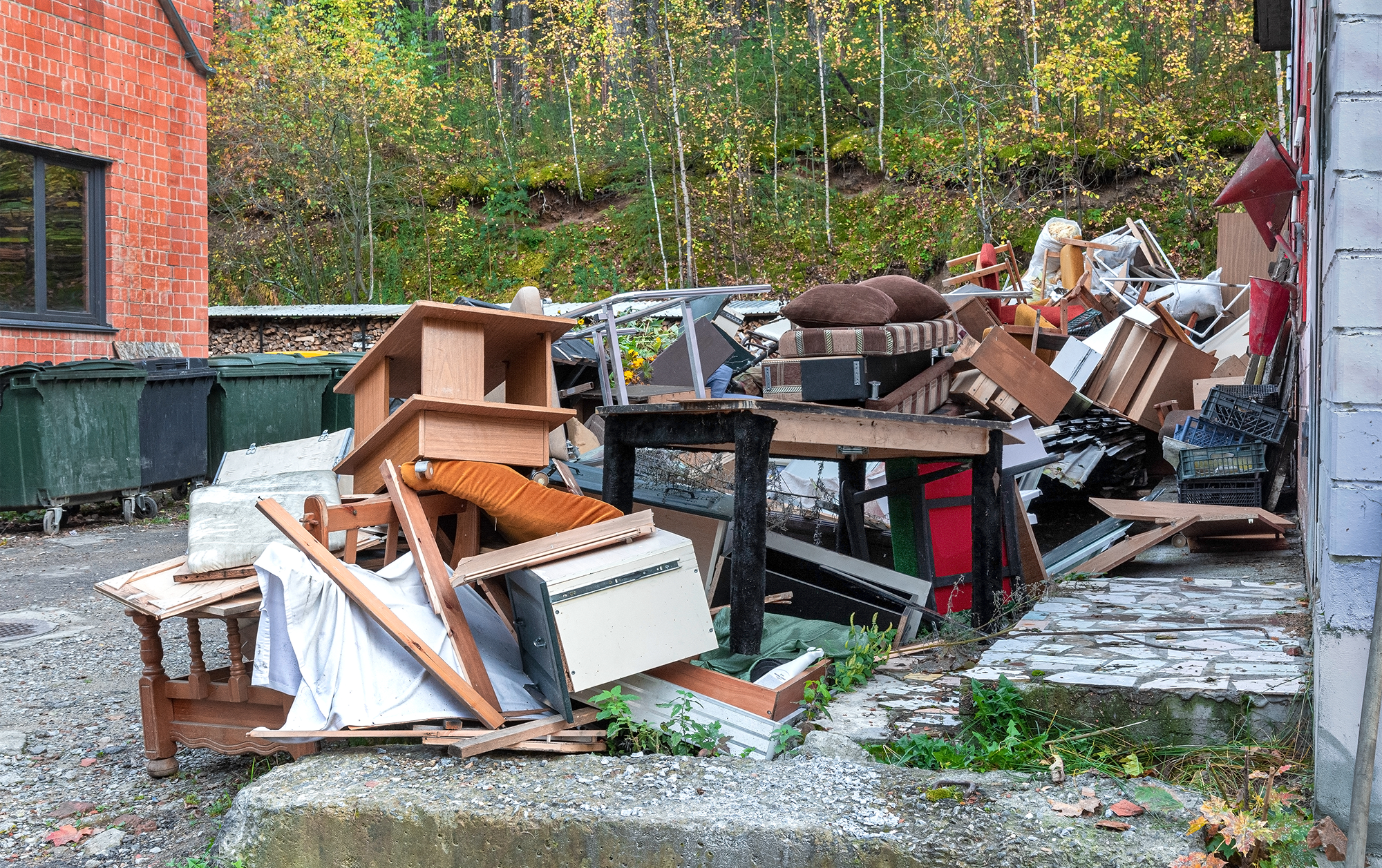 Discarded furniture and items in outdoor area.