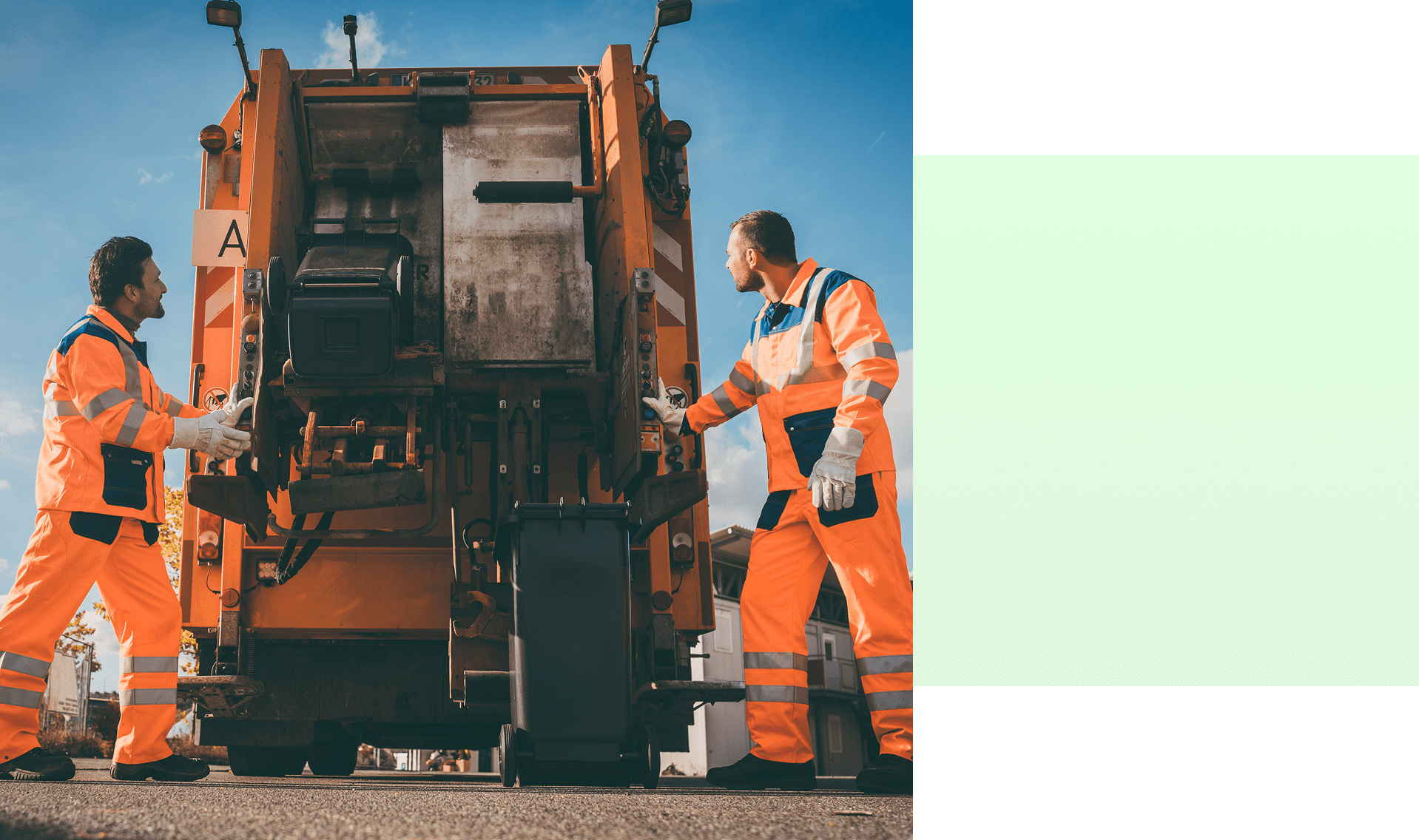 Workers operating an orange garbage truck.